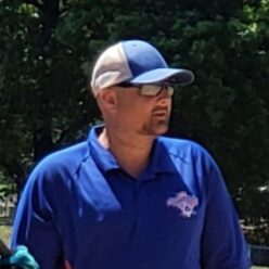 Jeremy Magers wearing a white and blue hat, blue shirt, and sunglasses