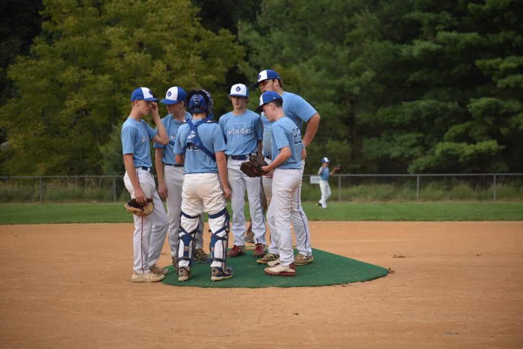 in the dirt baseball team huddled together