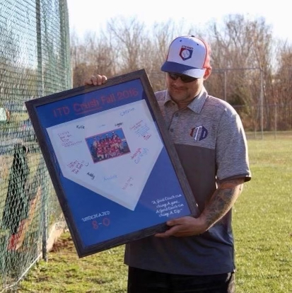 jeremy magers holding a framed team photo
